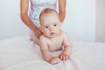 Woman doing exercises and massage the baby