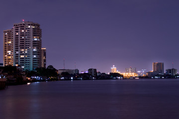 Fototapeta na wymiar At night, the lights of the big city near the river.