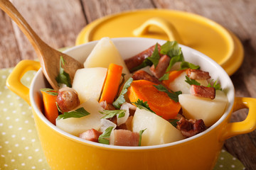 Irish coddle with pork sausage, bacon and vegetables close-up. horizontal
