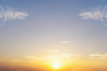 Blue sky and orange light of the sun through the clouds in the s