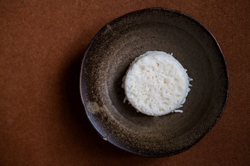 Rice on terracotta brown; organic healthy food cuisine