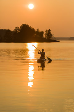 Paddle-boarding on lake during sunset