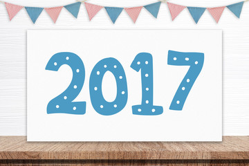 2017 on white board and party flags hanging on white wood 