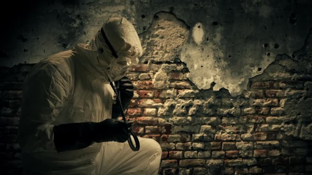 An old dilapidated brick wall is the background for this doctor wearing full protection against exposure to the Ebola virus while caring for someone off scene.