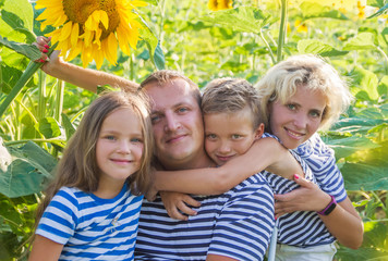 Fototapeta premium Family with two children in sunflower field