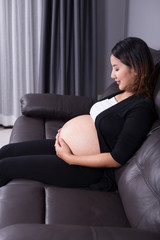 pregnant woman resting at home on sofa