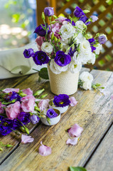Bouquet of roses in a vase on a wooden table.