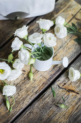 Bouquet of roses in a vase on a wooden table.