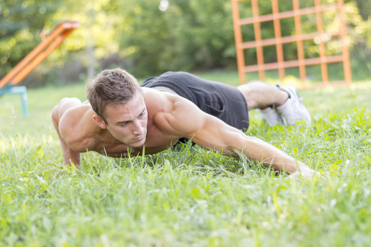 Push-ups - Fitness Man Training Push Up Outside In Grass In Summer.