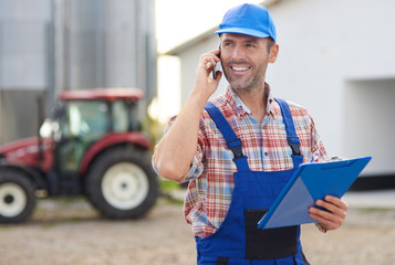 Farmer controlling his agricultural business © gpointstudio