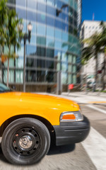 Yellow cab speeding up along city streets