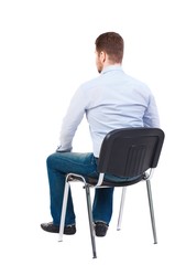 back view of business man sitting on chair. Bearded businessman in white shirt sits on a chair and...