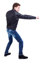 Naklejka premium back view of guy funny fights waving his arms and legs. Curly guy in a black leather jacket fun waving his arms.
