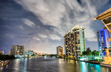 Miami buildings at night with river reflections