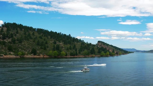 A picturesque view of the calm waters of Horsetooth Reservoir Located in the foothills west of Fort Collins Colorado with a few recreational boaters in sight.