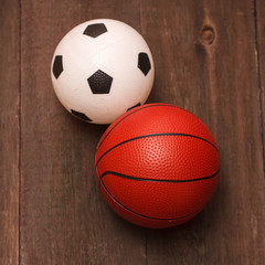 children's football and basketball balls on a wooden background