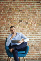 Thoughtful man with digital tablet.