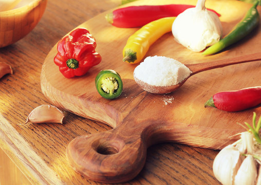 different variety of hot peppers and spices on cutting board