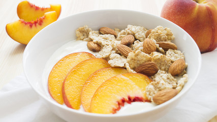 Whole grain cereal with fresh peach fruit, yogurt and almond in