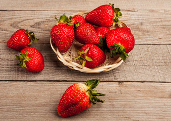 Lots of nice, fresh, spring strawberries with green leaves in a pile.
