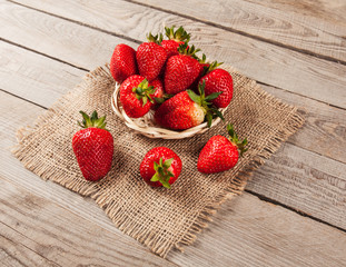 Lots of nice, fresh, spring strawberries with green leaves in a pile.