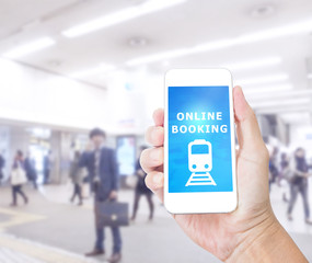 Hand holding smartphone with Online Booking on blurred image of