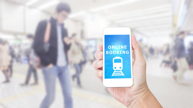 Hand holding smartphone with Online Booking on blurred image of