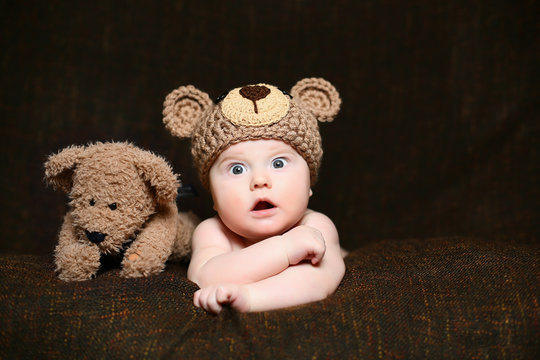 Cute Amazed Baby With An Open Mouth And Crossed Arms