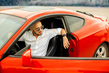 Fototapeta na wymiar handsome man in sunglasses in sport car
