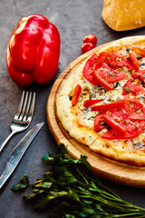 Fresh hot pizza with Parmesan Cheese,bell pepper, parsley and tomatoes