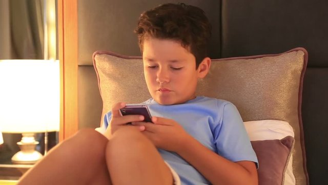 Child using mobil phone in home. Smartphone addiction