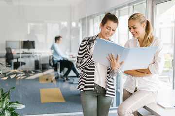 Business people working on blueprints in office