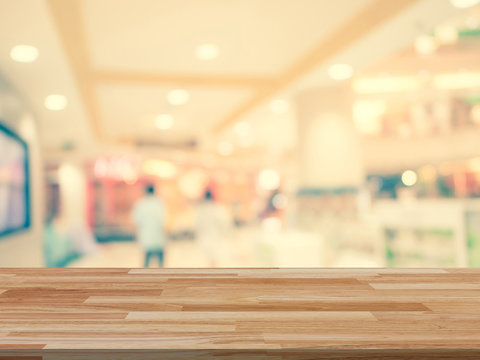 Wood table and shopping mall Blurred background with space
