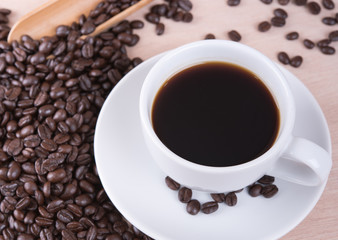 Coffee cup and coffee beans on wood table in coffee shop