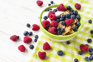 Healthy corn flakes breakfast on the white wooden table