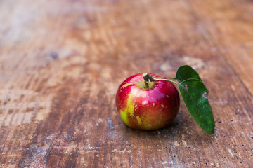 Red ripe apples at dark wooden table.