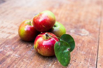 Red ripe apples at dark wooden table.