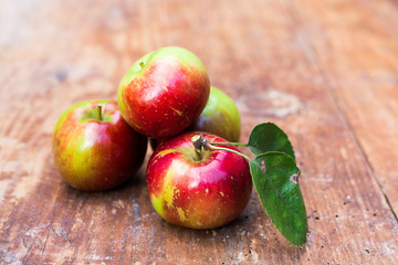 Red ripe apples at dark wooden table.