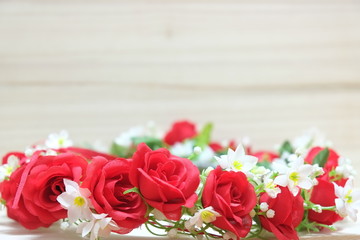 bouquet of artificial red roses on a wood background