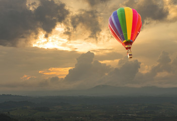 Naklejka premium Hot air balloon over the hill at sunset
