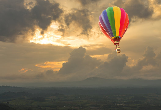 Hot air balloon over the hill at sunset