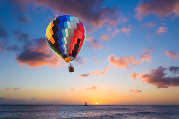 Fototapeta na wymiar Hot air balloon over the sea at sunset