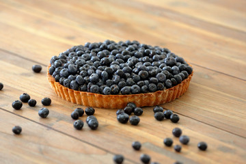Tart with fresh blueberries on a wooden background
