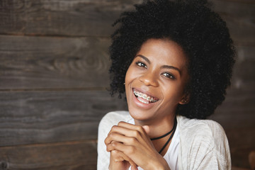 People and happiness concept. Cheerful African American young woman smiling at camera showing her...