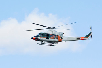 Obraz na płótnie Canvas White-orange helicopter is flying