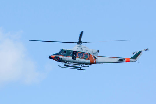 White-orange helicopter is flying