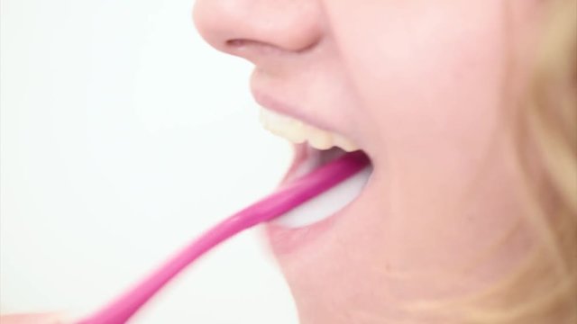 Close up of mouth while brushing. Girl with toothbrush in bathroom. Oral hygiene. Female in the morning or the evening in bath room, cleaning oral cavity caring about dental health.