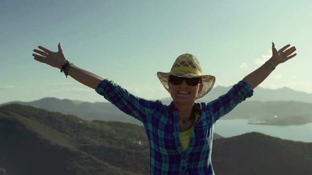Woman standing on the hill and feeling free, steadycam shot
