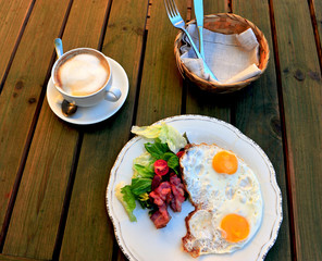 Sunny side up eggs with bacon and vegetables and coffee cup