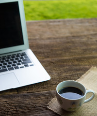 Laptop with a cup of coffee on the old wooden table, working, bright, happy.